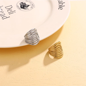 Detail of layered gold and silver stainless steel rings on a ceramic plate edge
