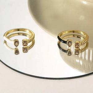 Detail of copper ring with zircon stones and enamel drip on a mirrored surface