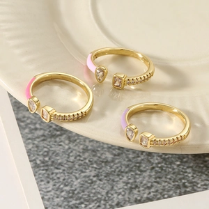 Detailed shot of three gold-plated enamel rings with rhinestones on a ceramic plate