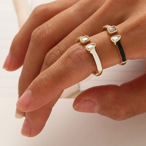Detail of adjustable gold-plated rings with black and white enamel and zircon accents