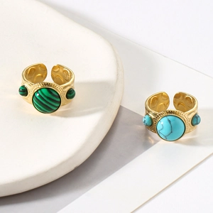 Detail of vintage gold rings with textured metal and inlaid green and blue natural stones