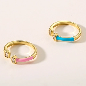 Detail of gold-plated copper rings with pink and blue enamel and sparkling zircon stones