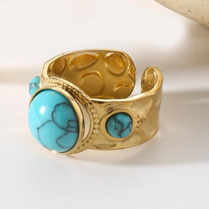 Detail of vintage gold ring with hammered texture and turquoise gemstone inlaying
