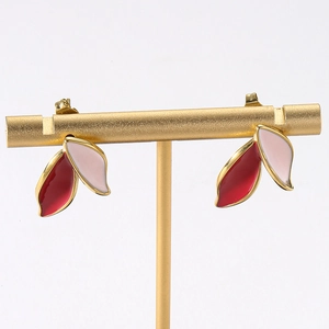 Detail of leaf-shaped earrings featuring pink and burgundy enamel on gold plated metal