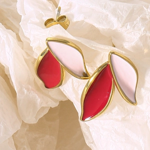 Detail of gold leaf earrings with red and white enamel drip oil and metallic edges