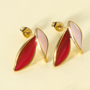 Detailed macro view of leaf-shaped earrings with red and pink enamel and gold-plated edges
