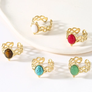 Set of retro hollowed gold-plated open rings with colorful natural stones on white board