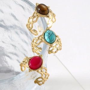 Three elegant vintage hollow rings with oval stones in brown, green and red on glass