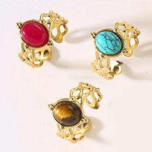 Detail of vintage gold rings with hollow patterns and colorful oval natural stone inlays