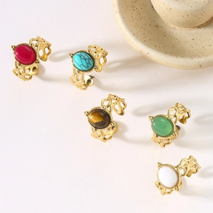 Detailed view of vintage gold hollow rings with colorful natural stones on white surface