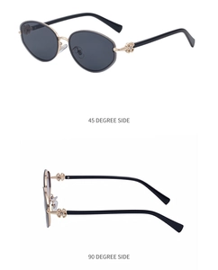 Detail of oval sunglasses featuring gold metal frames and hollow floral temple design