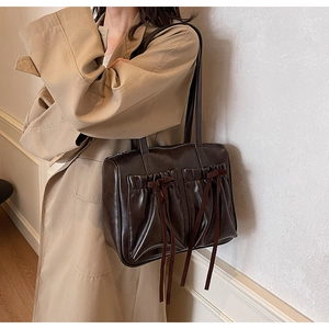Detail of vintage brown shoulder bag with pleated pockets and delicate bow accents