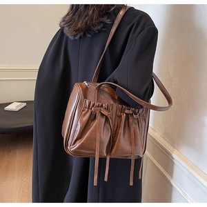 Detail of vintage brown shoulder bag showing retro texture and drawstring bow pockets