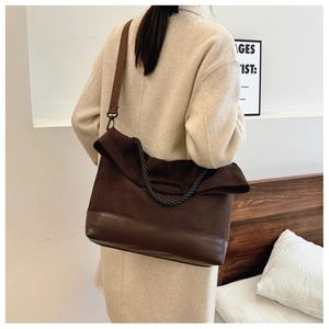 Detail of vintage brown suede shoulder bag with woven handle and adjustable wide strap