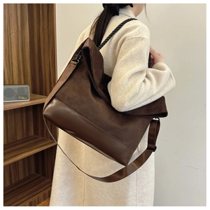 Brown vintage tote bag with mixed textures shown on model in a cozy interior