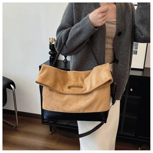Detail of camel suede and black leather patchwork tote bag with woven rope shoulder strap