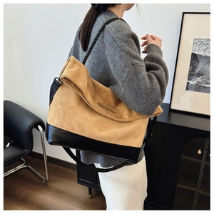 Detail of minimalist tote bag showing khaki suede and black leather patchwork design