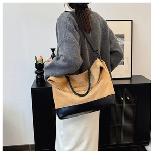 Detail of a large khaki and black suede patchwork tote bag with adjustable nylon strap
