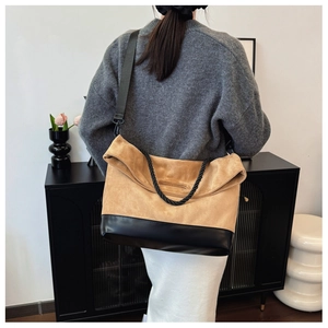 Detailed view of camel suede tote bag with black leather base and thick rope handle