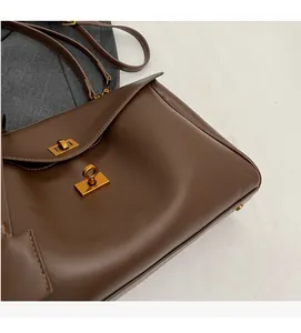 Gros plan d'un cabas vintage en cuir marron avec fermoir tournant en métal doré élégant
