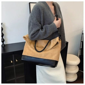 Detail of vintage tote bag showing camel suede and black leather stitching with rope handle