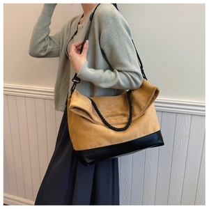 Detail of vintage yellow suede tote bag with woven handles shown in use with casual outfit