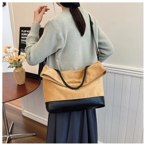 Detail of camel suede and black leather patchwork on a large tote bag with braided handle