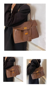 Détail du sac fourre-tout en daim marron caramel avec boucles dorées et patchwork cuir