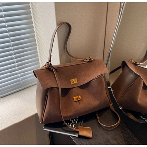 Vue détaillée d'un sac cabas en daim marron foncé avec boucles dorées vintage