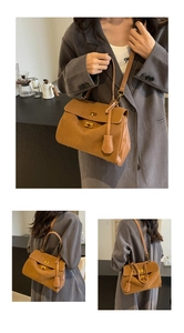Détails du sac à main marron en daim avec des boucles en métal doré et bandoulière