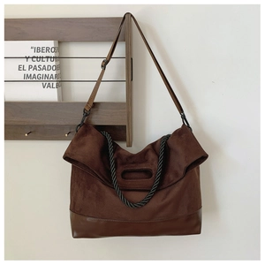 Detail of vintage brown suede tote with leather base and black braided handles