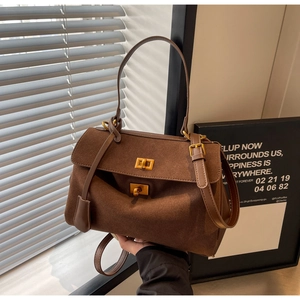 Détail du sac à main vintage marron foncé avec finition mate et fermoir pivotant en métal doré