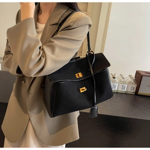 Vue détaillée du grand sac cabas en suédine noire avec fermoir rotatif en métal doré