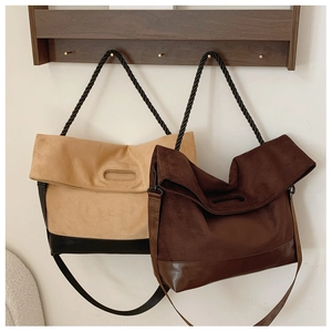 Detail of vintage large tote bags in suede and leather with twisted handles hanging