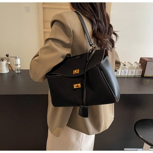 Détail du sac cabas en daim noir avec fermoirs tournants dorés et étiquette en cuir