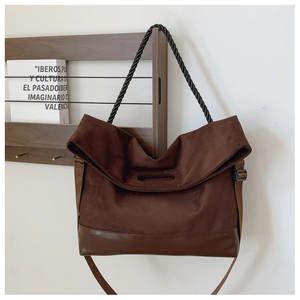Detail of dark brown suede tote bag with woven handle and adjustable crossbody strap