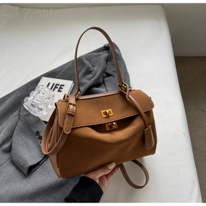 Gros plan du sac à main marron en cuir dépoli avec fermoirs rotatifs dorés