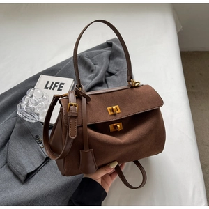Détail du sac cabas marron en daim avec double fermoir doré et bandoulière en cuir