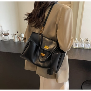 Détail du sac cabas en daim noir avec double fermoirs dorés et bandoulière longue
