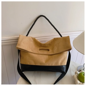 Close-up of contrast stitching tote bag with camel suede and black leather material