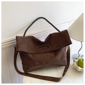 Detail of vintage brown suede tote bag with woven rope handle and crossbody strap