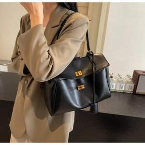 Détails des fermoirs rotatifs dorés sur le grand sac cabas en suède noir