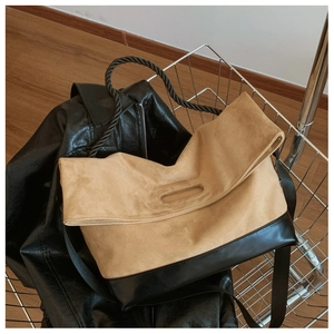 Detail of vintage large capacity tote bag with khaki suede and black leather patchwork