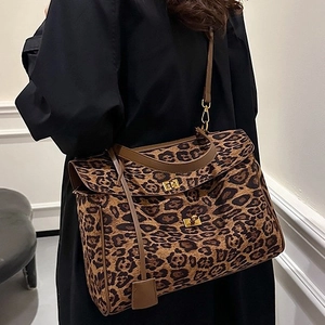 Women's leopard print tote bag with gold twist lock shown on model's shoulder