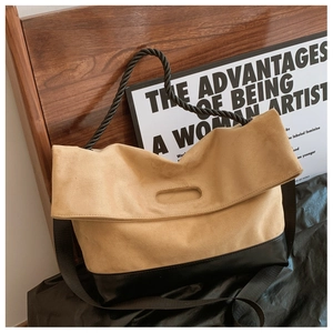Detail of the brown suede and black leather patchwork bag with a thick twisted rope handle