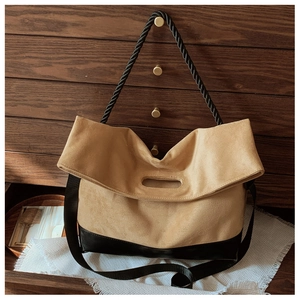 Detail view of contrast stitching tote with rope handles and suede leather texture