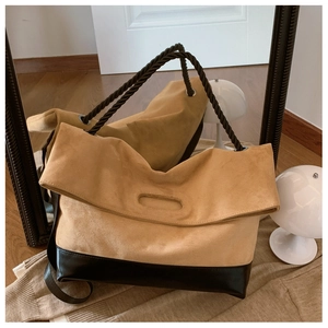 Detail of the color-block tote bag featuring camel suede and black leather textures