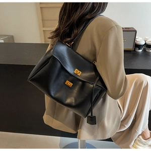Détail du grand sac cabas en suédine noire avec fermoirs dorés et breloque en cuir