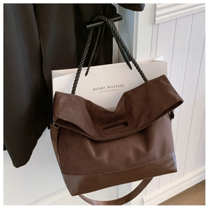 Detail of coffee brown tote bag featuring suede texture and twisted rope handle detail