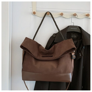 Detail of dark brown tote bag featuring suede texture and braided rope handle